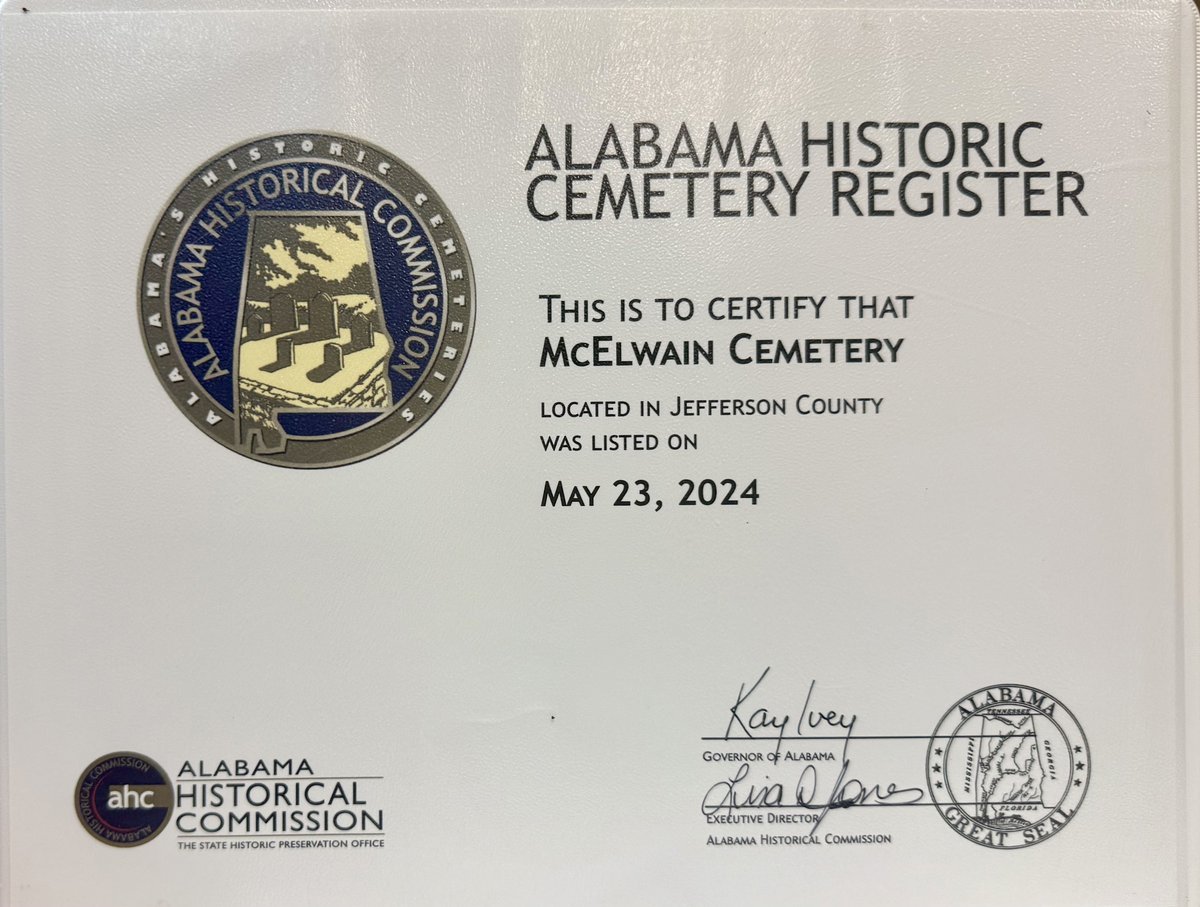 Headstones among mature oaks and cedars in McElwain Cemetery